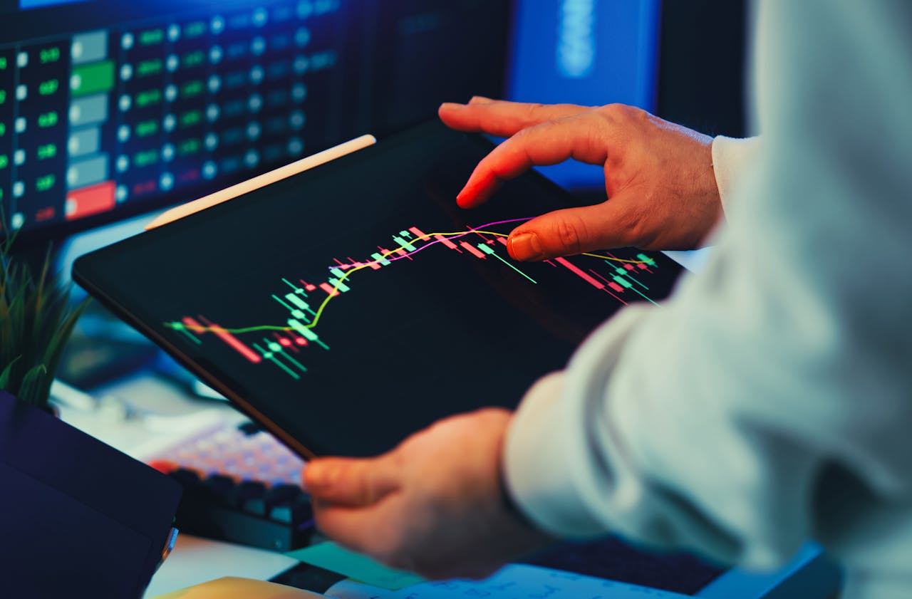Mastering the First Impression: Your intriguing post title goes here A close-up of a person using a tablet to analyze stock market trends and charts indoors.