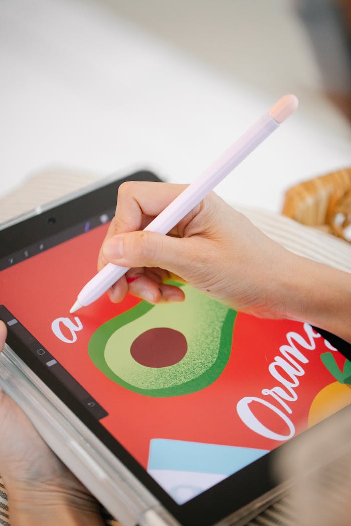 Close-up of a hand using a stylus pen for digital art on a tablet.